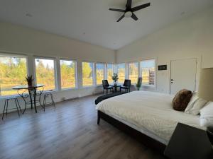 a bedroom with a large bed with a ceiling fan at Country home, Sleeps 6 pets friendly in Port Alberni