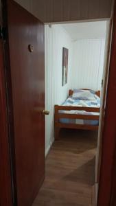 a door leading to a bedroom with a bed at Hostal Valentino Villarrica in Villarrica