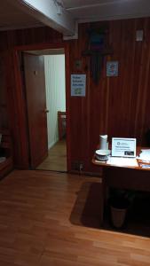 Habitación con escritorio, puerta y mesa. en Hostal Valentino Villarrica, en Villarrica