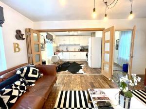 a living room with a couch and a kitchen at Gorgeous 2 bedroom apartment edge of Cabot Circus in Bristol