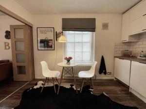 a kitchen with a table and two chairs and a table at Gorgeous 2 bedroom apartment edge of Cabot Circus in Bristol