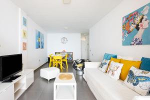 salon z białą kanapą i telewizorem w obiekcie Frontline Penthouse with heated pool and parking w mieście Los Cristianos