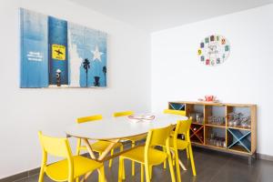 jadalnia ze stołem i żółtymi krzesłami w obiekcie Frontline Penthouse with heated pool and parking w mieście Los Cristianos