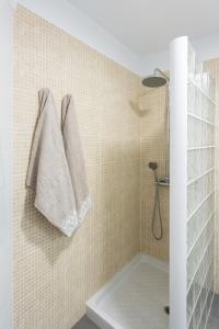 łazienka z prysznicem i 2 ręcznikami wiszącymi na ścianie w obiekcie Frontline Penthouse with heated pool and parking w mieście Los Cristianos