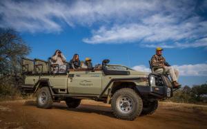 um grupo de pessoas a andar na parte de trás de um jipe em Imagine Africa Luxury Tented Camp em Balule Game Reserve