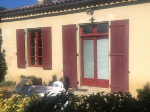 a house with red doors and a car parked outside at Maison de campagne in Rions