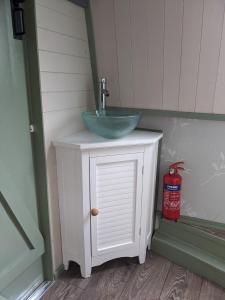 a bathroom with a sink and a counter with a fire extinguisher at Mini Escape - 2 Berth Narrowboat on the Grand Union, Hertfordshire 