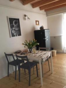 a dining room table with chairs and a refrigerator at Kosikome in Ferrara