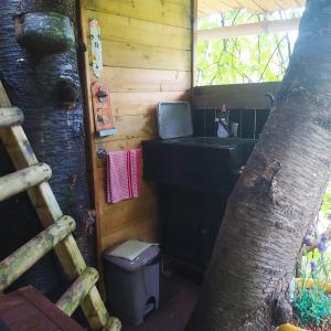 a bathroom with a sink and a toilet in a tree at CABANE CERISE DANS L'ARBRE Etapeboisee in Fumay