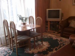 sala de estar con mesa, sillas y TV en Jomas 24, en Jūrmala