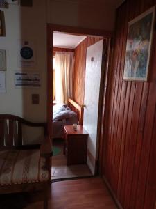 a bedroom with a bed and a door leading into a room at Hostal Valentino Villarrica in Villarrica