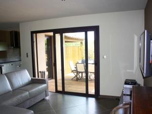 een woonkamer met een deur naar een patio bij Appartement de 3 chambres avec piscine partagee jardin clos et wifi a Porto Vecchio a 1 km de la plageB in Porto-Vecchio