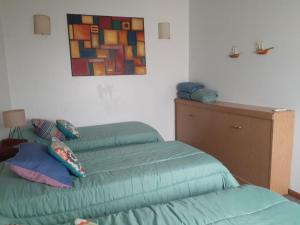 sypialnia z 2 zielonymi łóżkami i obrazem na ścianie w obiekcie Apartment con terraza 1 piso por escalera w BuenosAires
