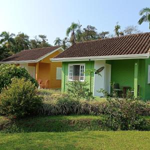 a green house with a brown roof at Pura Vida Residence in Morretes
