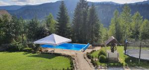 a backyard with a pool and an umbrella at L - Hutir in Mykulychyn