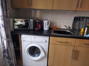 una cucina con lavatrice e lavandino di 1st Floor Hillview 2 bedrooms central location a Brean