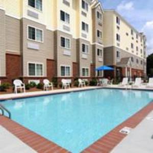 a large swimming pool in front of a building at Microtel Inn & Suites by Wyndham Columbus Near Fort Moore in Columbus