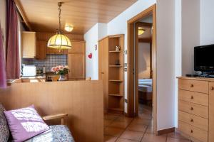 um pequeno quarto com uma cozinha e uma sala de estar em Cesa Soramurat Appartamento 9 em Canazei