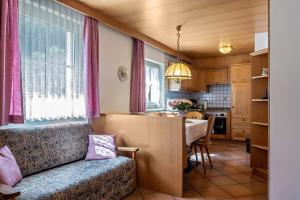 a living room with a couch and a kitchen at Cesa Soramurat Appartamento 9 in Canazei