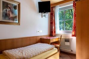 a small room with a bed and a window at Cesa Soramurat Appartamento 9 in Canazei