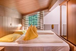 a bedroom with a large bed with yellow pillows at Cesa Soramurat Appartamento 8 in Canazei