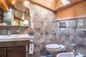 a bathroom with a toilet and a sink at Cesa Soramurat Appartamento 8 in Canazei +13 photos