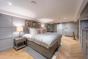 a bedroom with a large bed and a lamp on a table at No1 Apartments Edinburgh - New Town in Edinburgh
