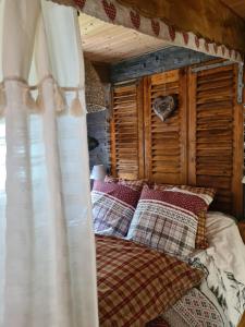 a bedroom with a canopy bed with pillows at Chez steph et frank in Morez