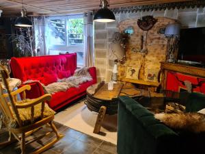 a living room with a red couch and a table at Chez steph et frank in Morez