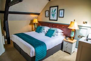 a hotel room with a large bed with blue pillows at Haighton Manor - Brunning and Price in Grimsargh