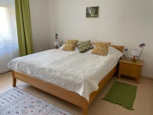 a bedroom with a large bed with pillows on it at Ferienwohnungen Berg & See in Döbriach