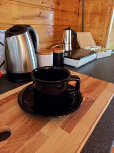 eine schwarze Kaffeetasse auf einem Schneidebrett in der Unterkunft The WoodHouse Vendégház in Nagymaros