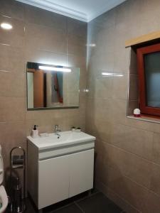 y baño con lavabo blanco y espejo. en Casa da Fonte em Prada, Vinhais, en Vinhais