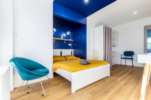 a bedroom with a bed and a blue wall at Le Bleu Royal Appart Hotel - 5 Chambres in Évry-les-Châteaux