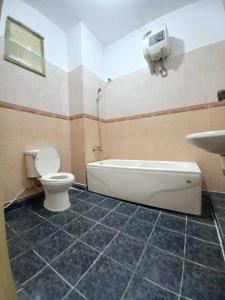 a bathroom with a tub and a toilet and a sink at Nhật An Hotel in Ho Chi Minh City +20 photos