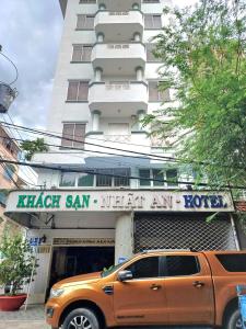 un camion arancione parcheggiato di fronte a un hotel di Nhật An Hotel ad Ho Chi Minh