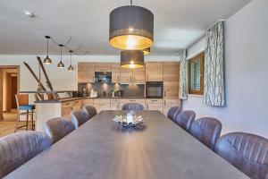 een eetkamer en een keuken met een grote tafel en stoelen bij AlpenParks Chalet & Apartment Steve Lodge Viehhofen in Viehhofen