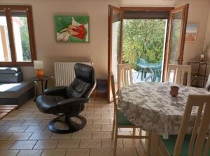 een woonkamer met een tafel en een stoel en een kamer bij Chez Nath in Wimille