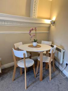 a table and chairs with a vase with flowers on it at Victorian Retreat in York