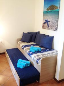 ein Bett mit blauen Kissen und blauen Handtüchern darauf in der Unterkunft La Perla in Monte Isola