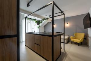 uma cozinha com um lavatório e uma televisão num quarto em Palais Hörtenberg em Bolzano