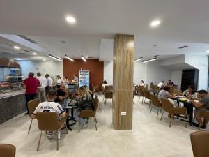 a group of people sitting at tables in a restaurant at Ladi Rooms in Tirana