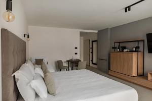 Un dormitorio con una gran cama blanca y una mesa en Palais Hörtenberg en Bolzano