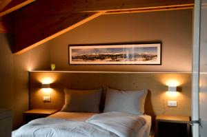 sypialnia z 2 łóżkami i 2 lampkami na ścianie w obiekcie Hotel Villa Argentina Ronzone w mieście Ronzone