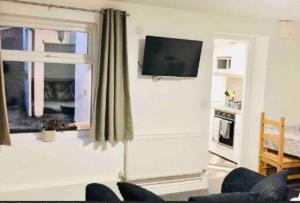 ein Wohnzimmer mit einem TV und einem Fenster in der Unterkunft Self contained studio in Chorley by Lancashire Holiday Lets in Chorley