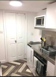 a kitchen with a stove and a microwave at Self contained studio in Chorley by Lancashire Holiday Lets in Chorley