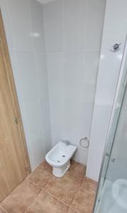 y baño blanco con aseo y ducha. en Suite Vintage Bariloche en San Carlos de Bariloche