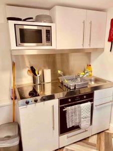 a small kitchen with a stove and a microwave at Self contained studio in Chorley by Lancashire Holiday Lets in Chorley