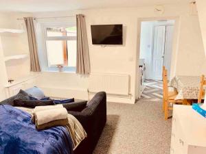 a living room with a couch and a flat screen tv at Self contained studio in Chorley by Lancashire Holiday Lets in Chorley