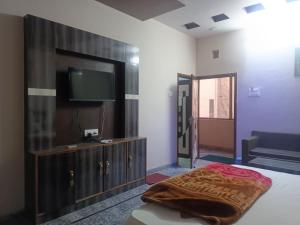 a bedroom with a tv and a bed and a couch at HOTEL ROYAL CHURU in Chūru